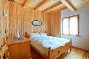 una camera con letto e parete in legno di Lioda Wood a Cibiana