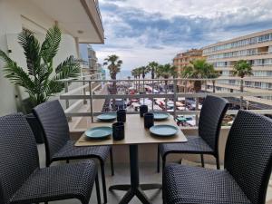 a table on a balcony with a view of the beach at La PerleCanet - vue mer au centre in Canet-en-Roussillon