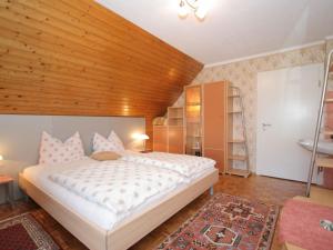 EberndorfにあるModern apartment with garden near the Petzen ski area in Eberndorf Carinthiaの木製の天井が特徴のベッドルーム1室(大型ベッド1台付)