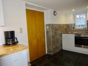 a kitchen with a wooden door and a counter top at Ferienwohnung Haus Barbara in Bad Brückenau +10 photos