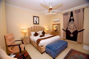 a bedroom with a king sized bed and a chair at Premier Inn Grand Gulberg Lahore in Lahore +90 photos