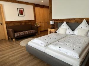 a bedroom with a large bed and a couch at Hotel Restaurant Neu Meran in Bad Reichenhall