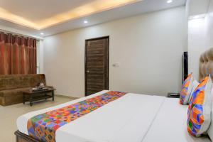 a bedroom with a large bed and a couch at FabHotel Classic in Bhopal +17 photos