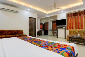 a bedroom with a bed and a living room at FabHotel Classic in Bhopal