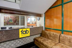 a couch sitting in a room with a jobhots sign at FabHotel Classic in Bhopal