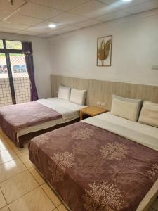 a hotel room with two beds and a window at Chihpen Hot Spring Hotel in Wenquan +10 photos