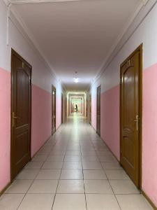 an empty hallway with pink and white walls and doors at Student Castle Almaty hostel in Almaty +2 photos