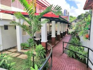 a porch of a building with a person walking down a sidewalk at 1898 Casa and Restaurante in Silay