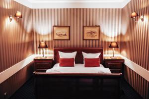 sypialnia z łóżkiem z czerwonymi poduszkami i 2 lampami w obiekcie Hotel Diament Bella Notte Katowice - Chorzów w mieście Chorzów