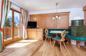 een keuken met een tafel en stoelen en een televisie bij Hotel Seelaus in Alpe di Siusi
