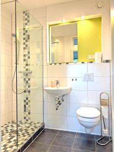 a bathroom with a toilet and a sink and a shower at Hammerhotel Apartments Halle Saale in Halle an der Saale