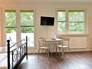a bedroom with a table and chairs and a bed at Hammerhotel Apartments Halle Saale in Halle an der Saale