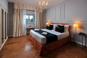 a bedroom with a large bed and a chandelier at Hotel Villa Carlotta in Florence
