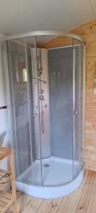 a glass shower in a room with a wooden floor at Le Chalet du Viaur in Tanus +18 photos