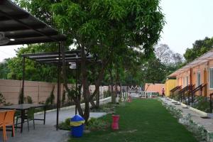 un giardino con tavolo, sedie e alberi di Hotel Divine Ayodhya- A Unit of Chinar Services a Ayodhya