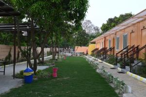 un cortile con erba e alberi accanto a un edificio di Hotel Divine Ayodhya- A Unit of Chinar Services a Ayodhya