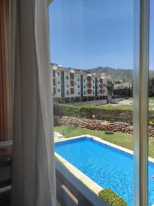 una finestra con vista sulla piscina. di La Colina - Playamar Apartamento a Torremolinos