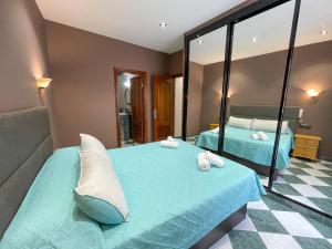a bedroom with two beds and a mirror at Apartamentos Illa de Arousa Centro 3000 in Isla de Arosa