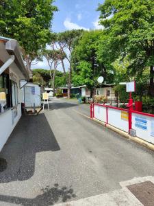 an empty street with a red fence and trees at Campeggio La Quiete in Marina di Massa