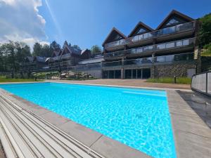een zwembad voor een gebouw bij Aparts4U - Kras Resort Apartament A302 z prywatnym jacuzzi, sauną i widokiem na góry in Szklarska Poręba