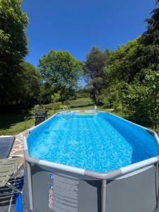 a large swimming pool with blue water at Le Cantou in Affieux