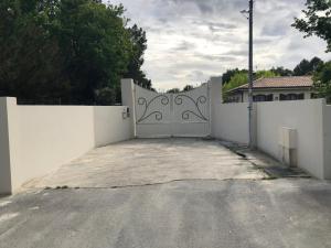 una cerca blanca con una puerta en la entrada en Mignon petit appartement indépendant en Mérignac