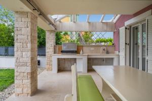 un patio con una mesa y un ordenador portátil. en Villa Violetta Residence, en Labin