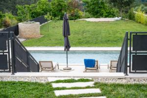 Dos sillas y una sombrilla junto a una piscina. en Villa Violetta Residence, en Labin