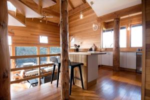ローンセストンにあるEsk Treehouse Cabin Unique Home with River Viewsの木製の壁のキッチン、カウンター(テーブル付)