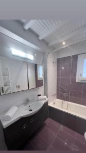 ein Badezimmer mit einem Waschbecken, einer Badewanne und einer Dusche in der Unterkunft Beautiful apartment in Mykonos town ! in Mykonos Stadt