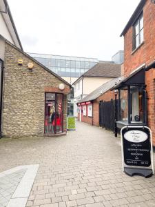 an empty street with buildings and a sign on the sidewalk at Exclusive 1 and 2 Bedroom Flats only 0,5 miles away from Bicester Village in Bicester