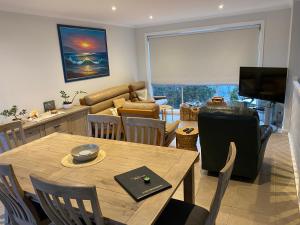 uma sala de estar com uma mesa e uma sala de jantar em Inverloch Cabins & Apartments em Inverloch