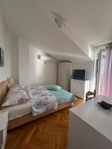ein Schlafzimmer mit einem Bett und einem Fernseher darin in der Unterkunft Apartman Marinac in Podstrana