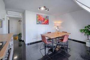 uma cozinha com uma mesa de madeira e cadeiras cor-de-rosa em Nibelungen Apartments em Worms