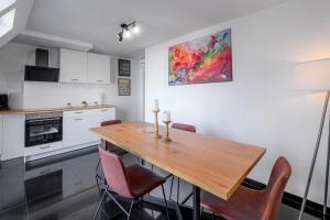 een keuken met een houten tafel en stoelen bij Nibelungen Apartments in Worms