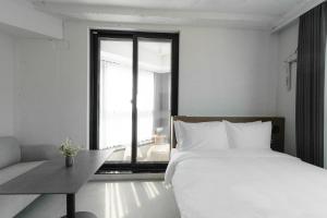 een slaapkamer met een wit bed en een groot raam bij Homes Stay G-Valley Gasan in Seoul