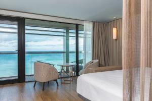 a hotel room with a bed and a view of the ocean at Oceania Saint Malo in Saint Malo