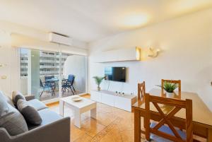 una sala de estar con un sofá y una mesa en Benalbeach playa - Tu hogar frente al mar, complejo 4 piscinas, en Arroyo de la Miel
