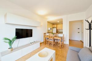 a living room with a couch and a tv at Benalbeach playa - Tu hogar frente al mar, complejo 4 piscinas in Arroyo de la Miel