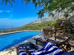 a swimming pool with a table and chairs next to a pool at Holiday home Stina Tučepi in Tučepi