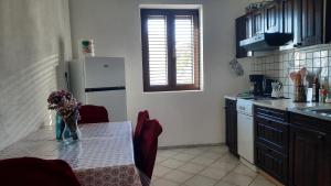 a kitchen with a table with a vase of flowers on it at Vlatković in Senj