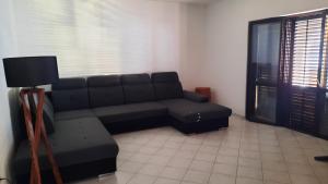 a living room with a black couch and a window at Vlatković in Senj
