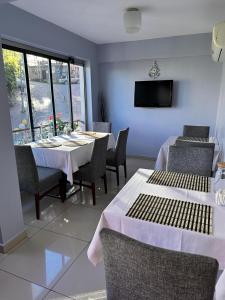 a dining room with a table and chairs and a tv at Lonca Butik Hotel in Giresun