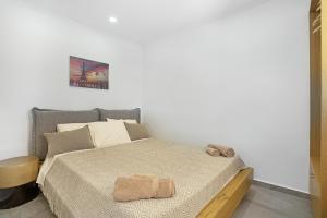 a white bedroom with a bed with a wooden headboard at Casa Della Nonna in Argostoli
