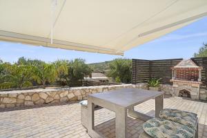 a patio with a table and chairs under a white umbrella at Casa Della Nonna in Argostoli