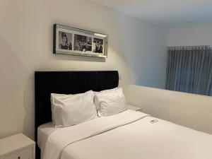 a bedroom with a bed with a picture on the wall at Splendid Apartments - Embassy Gardens in Accra