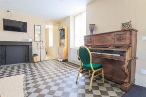 a living room with a piano and a chair at La ferme des Pommés in Pommera
