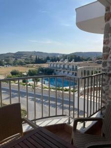 a balcony with a view of a swimming pool at PARASCHOS APARTMENTS Kardamaina in Kos