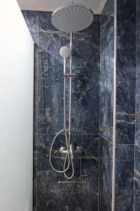 a shower in a bathroom with a black marble wall at PARASCHOS APARTMENTS Kardamaina in Kos +13 photos