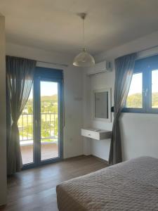 a bedroom with a bed and a large window at PARASCHOS APARTMENTS Kardamaina in Kos